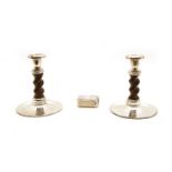 A pair of turned wooden on white metal mounted candlesticks,