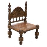 An oak Afghan-style low chair,