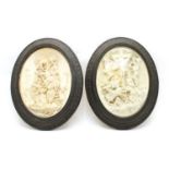 A pair of oval relief plaster plaques of the Crucifixion,