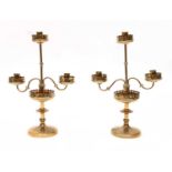 A pair of gothic brass three-light candelabra