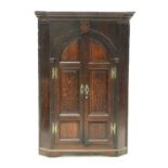 A George III oak hanging corner cabinet