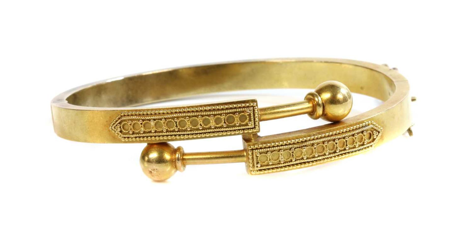 A Victorian gold, Archaeological Revival, Etruscan-style crossover hinged bangle, c.1870,