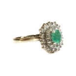 A white gold emerald and diamond cushion-shaped cluster ring,