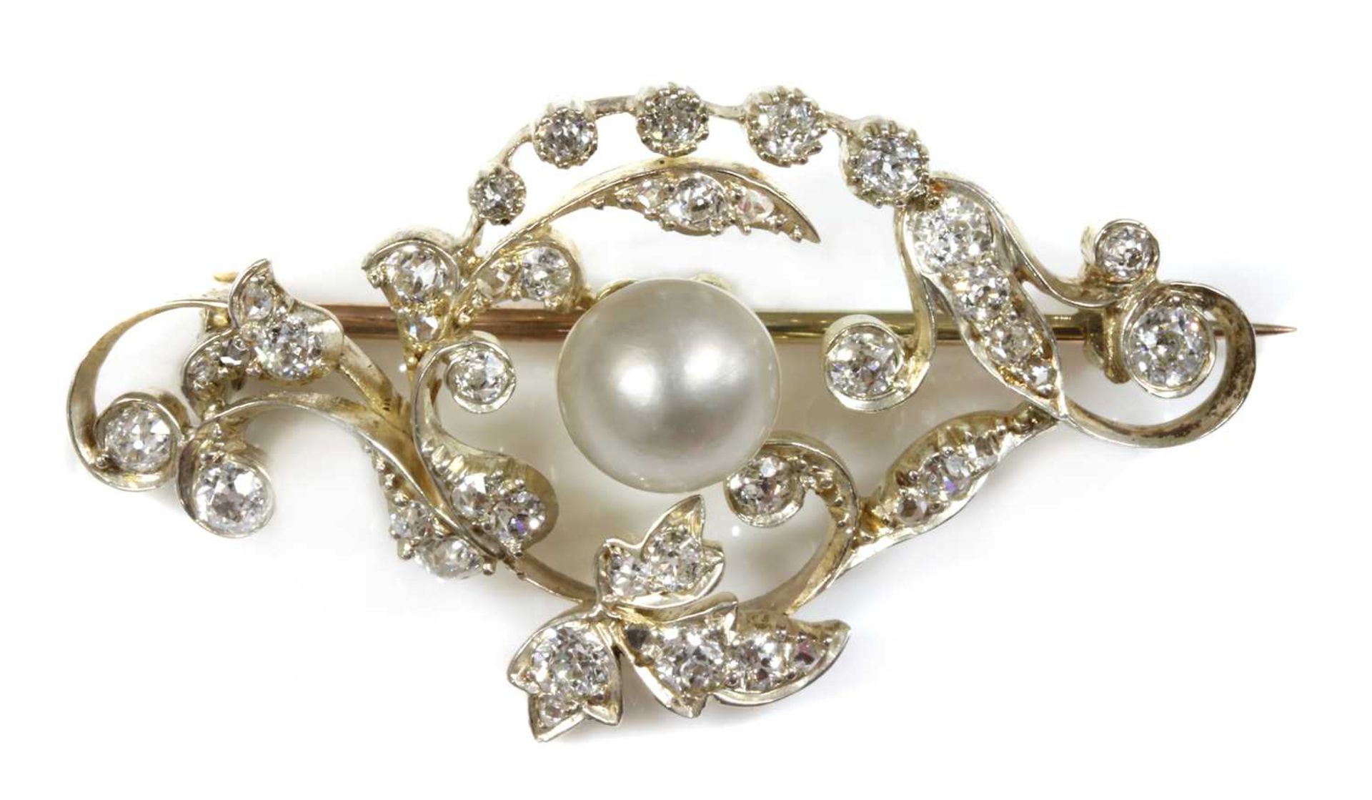 A late Victorian pearl and diamond scrolling brooch,