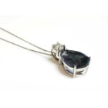 A white gold two stone tanzanite and diamond pendant,