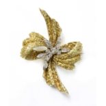 An 18ct yellow and white gold diamond set bow brooch, c.1970,