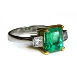 An 18ct yellow and white gold, three stone emerald and diamond ring,