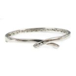 An 18ct white gold diamond set crossover bangle,