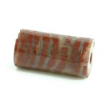 A Babylonian red banded jasper cylinder seal,