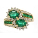 An 18ct gold emerald and diamond cluster crossover ring,