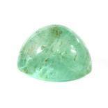 An unmounted oval cabochon emerald,
