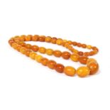 A continuous single row graduated olive-shaped butterscotch amber bead necklace,
