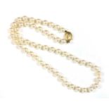 A single row uniform cultured pearl necklace with gold diamond clasp,