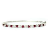 A white gold ruby and diamond hinged bangle,