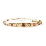 A gold diamond and gem set bangle,