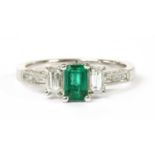 A white gold emerald and diamond three stone ring,