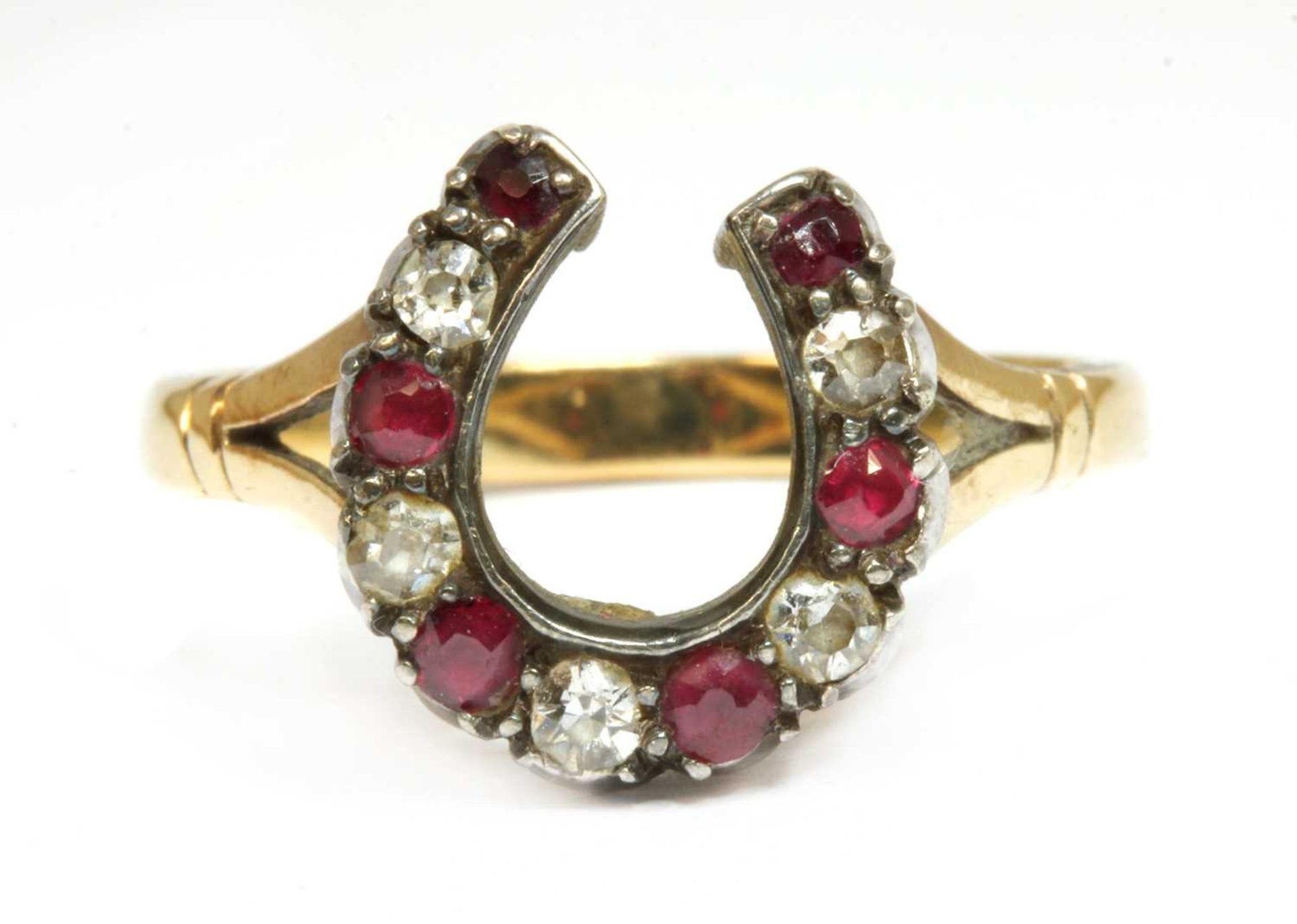 A gold and silver, diamond and ruby, horseshoe ring,