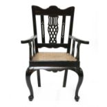 A Sri Lankan solid ebony elbow chair,