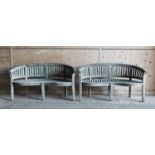 A pair of Lutyens-style curved teak garden benches,