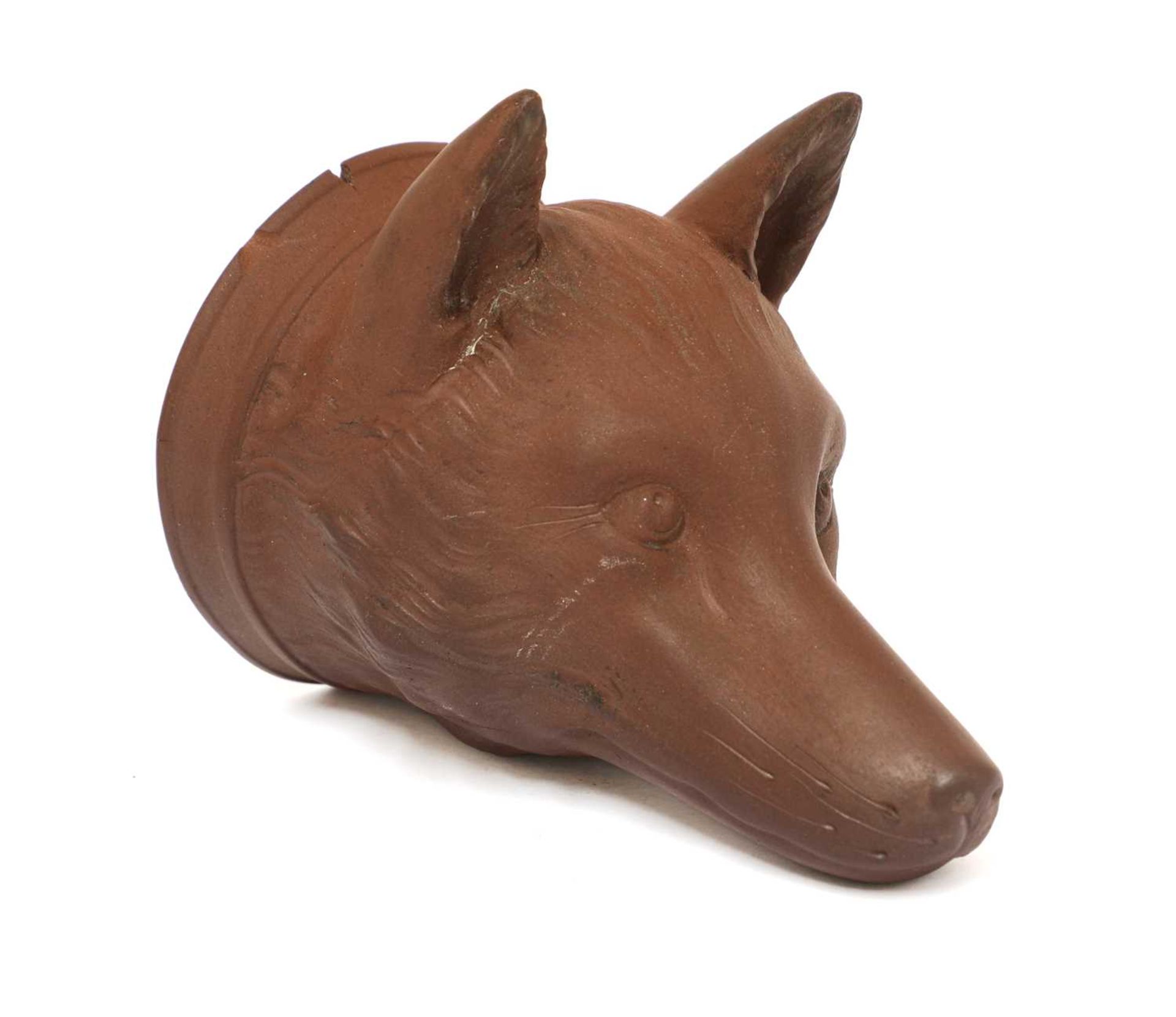 A rare Staffordshire redware fox mask stirrup cup,