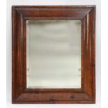 A walnut cushion-framed wall mirror,