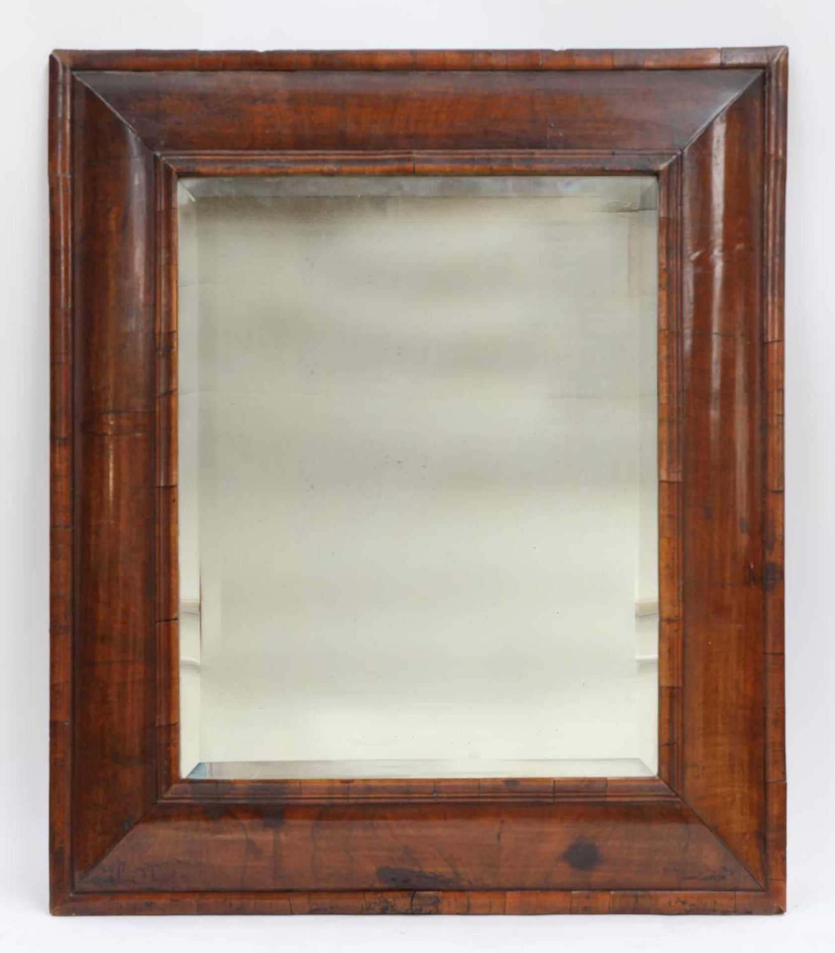 A walnut cushion-framed wall mirror,