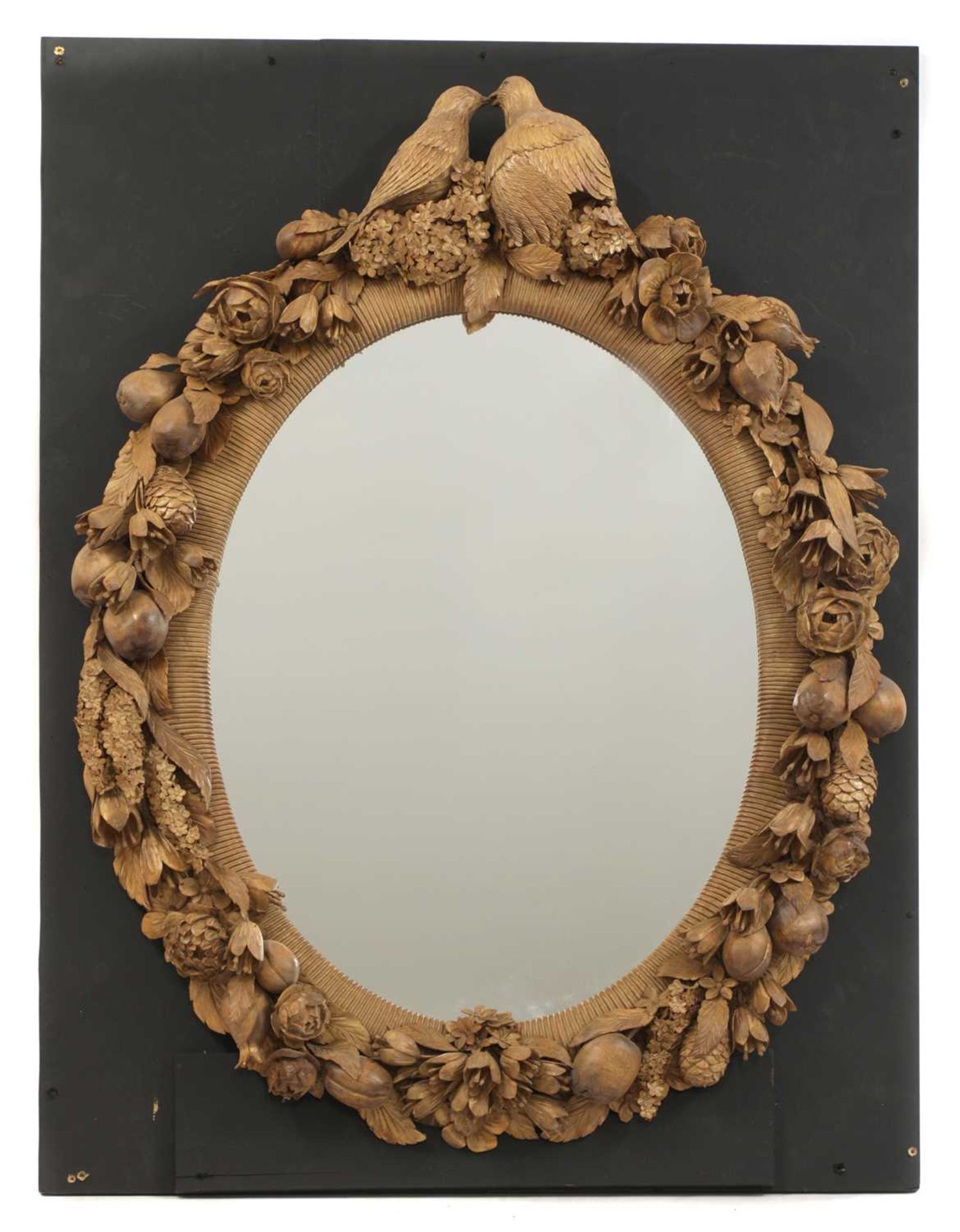An ornately carved mirror in the style of Grinling Gibbons,