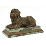 A bronze figure of a recumbent terrier,