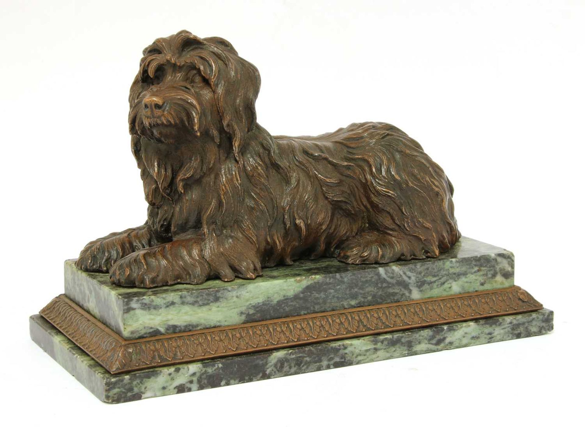 A bronze figure of a recumbent terrier,