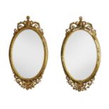 A pair of Victorian gilt gesso oval wall mirrors,