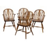 A set of four walnut and fruitwood wheel back Windsor chairs,