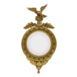 A Regency-style carved giltwood convex wall mirror,