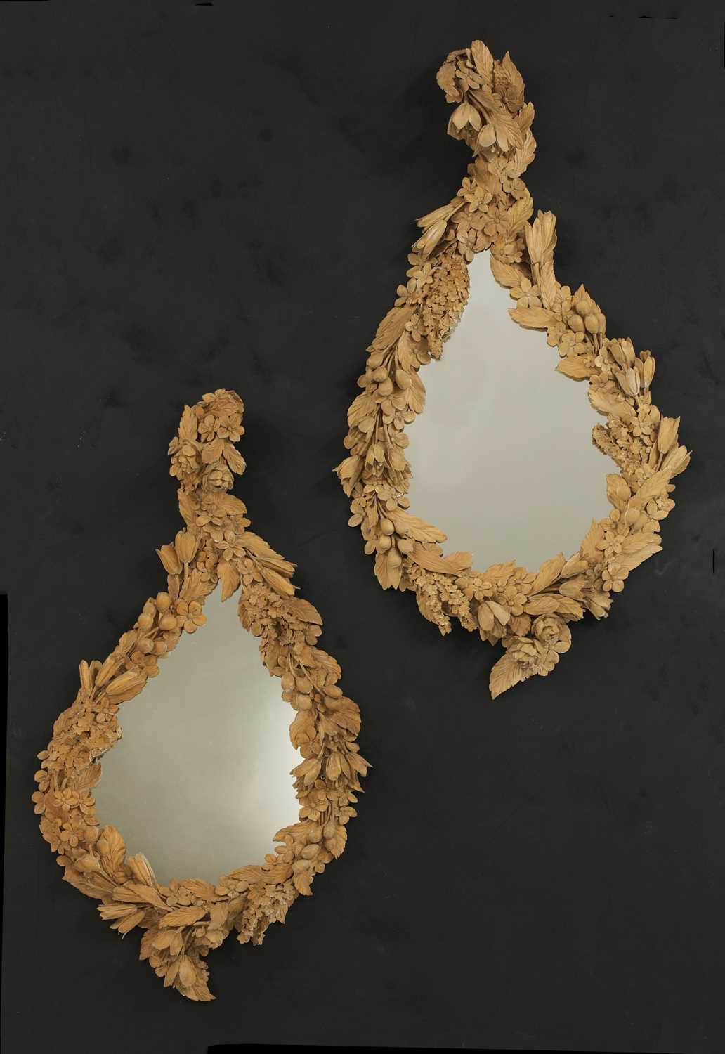 A pair of carved mirrors in the style of Grinling Gibbons,