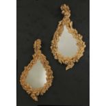 A pair of carved mirrors in the style of Grinling Gibbons,