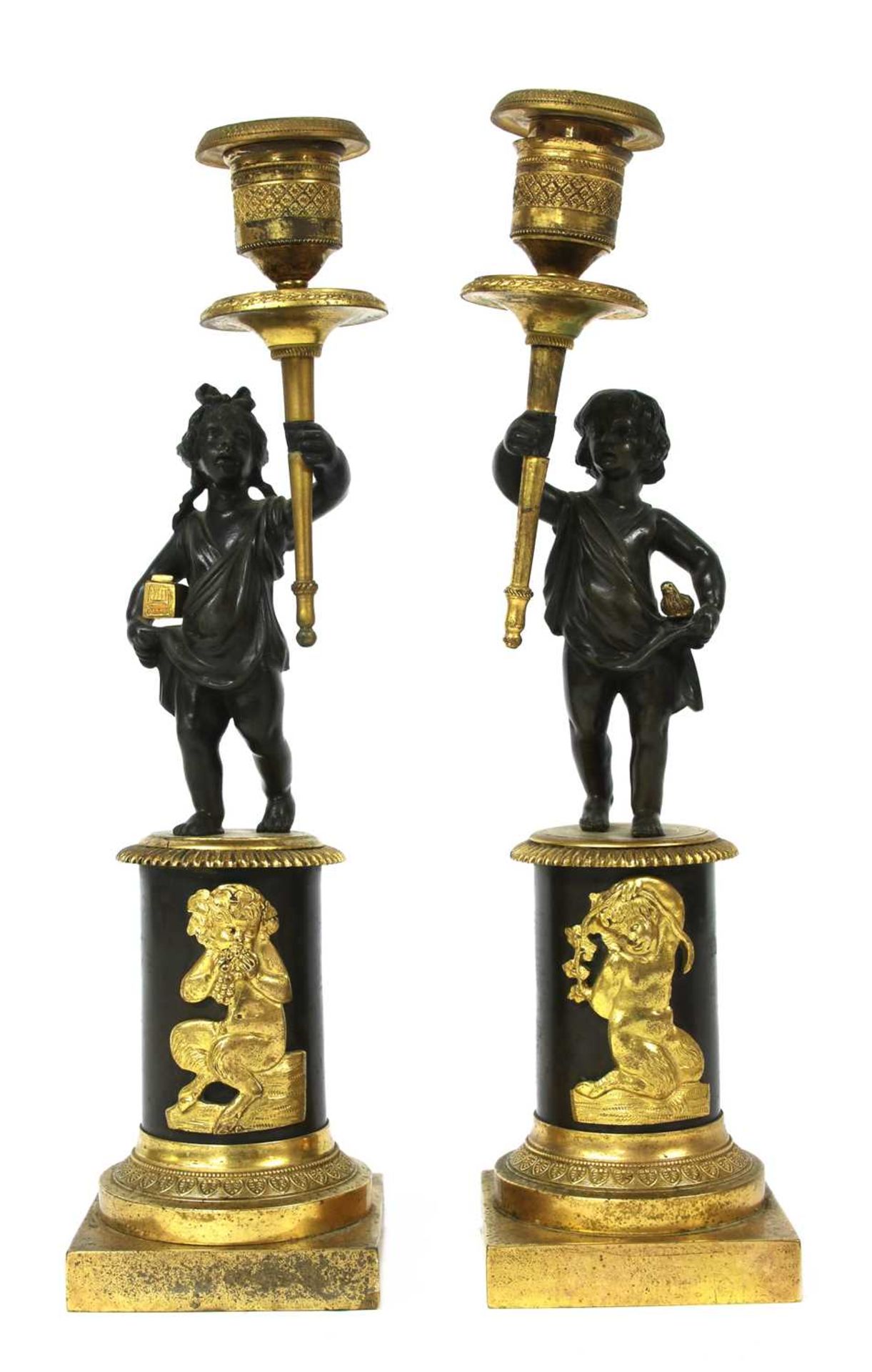 A pair of bronze parcel-gilt figural candlesticks,