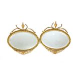 A pair of neo-classical style oval wall mirrors