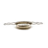 A silver wine strainer,