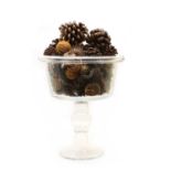 A large glass pedestal vase filled with pot pourri,