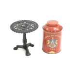 A black painted cast iron trivet in the form of a tripod table,