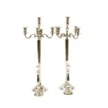 A pair of modern floor standing polished aluminium four light candelabra,