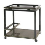 A black and gold two tier trolley, by Pierre Vandel,