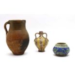 An antique earthenware part-glazed jug,