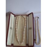 A string of varying sized white and pink coloured pearls within a Garrard & Co., case; together with