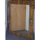 A large 19th century wallhanging looking glass; ornate gilt frame, each side headed with a scallop-
