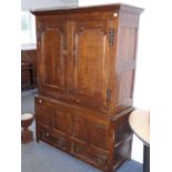 An 18th century oak press cupboard; outset cornice above two-fielded panel doors enclosing hanging