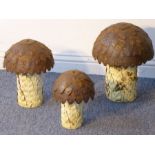 An unusual set of three graduated tin garden ornaments modelled as 'mushrooms', the largest head
