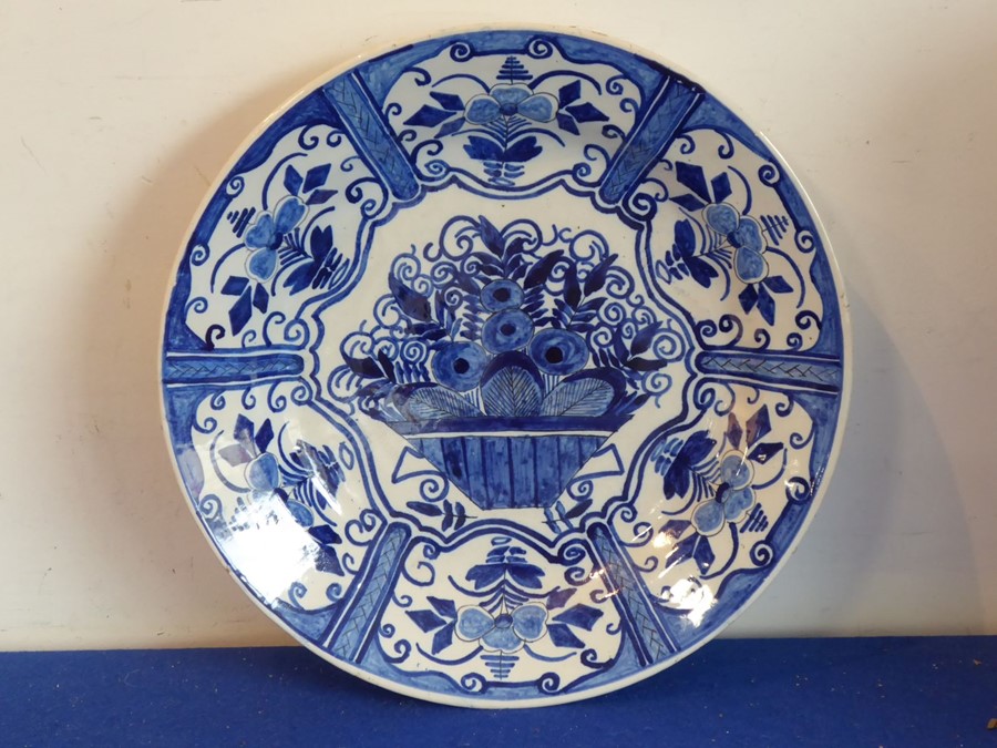 An 18th century Delftware charger hand-decorated in cobalt-blue with a central flower basket and six - Image 2 of 4