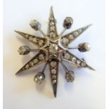 An early 20th century white-metal star-shaped brooch mounted with approx. 27 of old-cut diamonds,