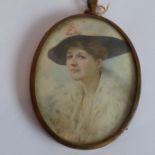 An early 20th century oval shoulder-length portrait of a young lady with wide brimmed hat, pearl