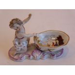 A 19th century Meissen porcelain salt modelled as a cherubic figure behind a shell-shaped bowl;